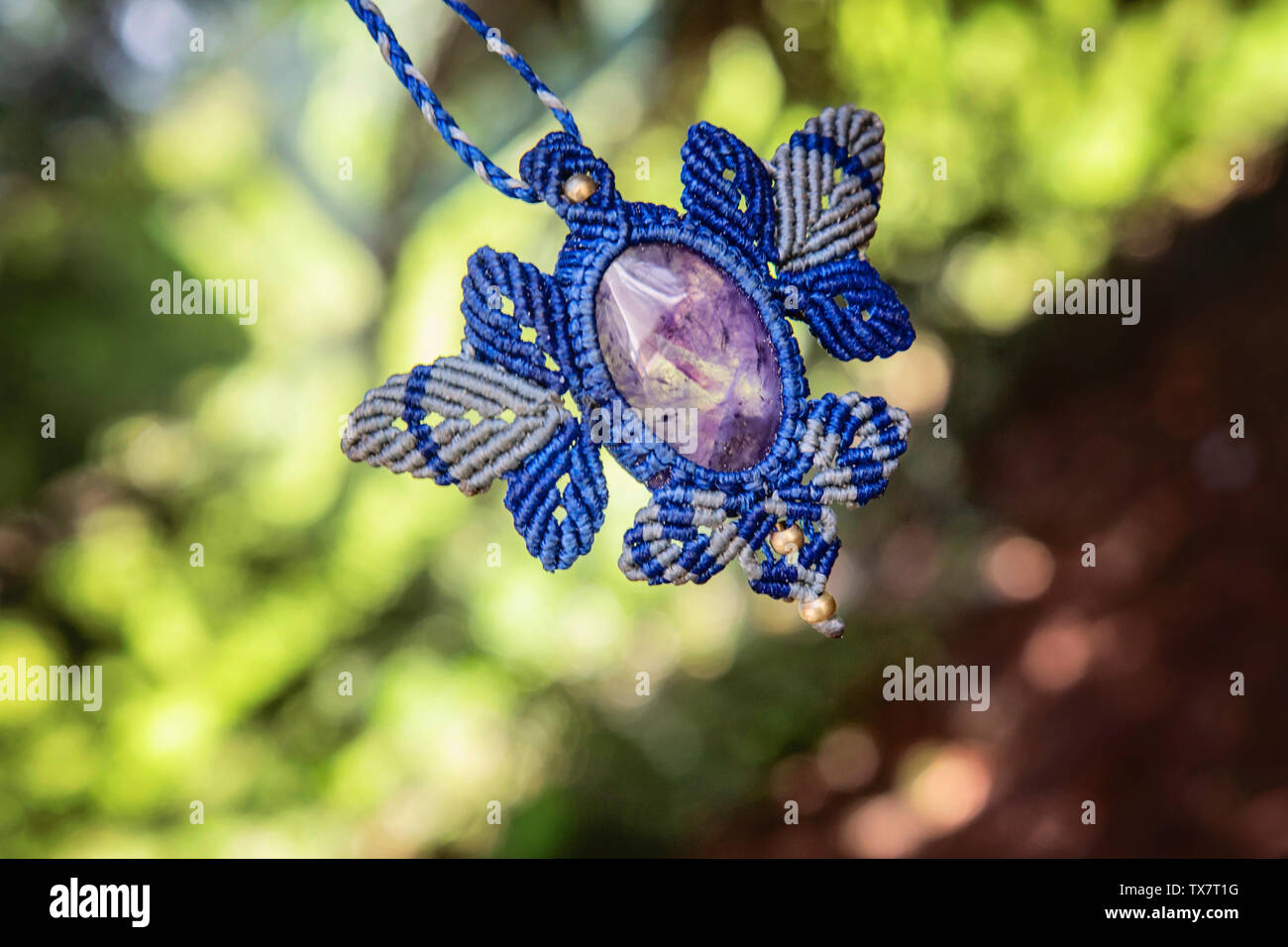 Macrame necklace with amethyst stone on natural background Stock Photo