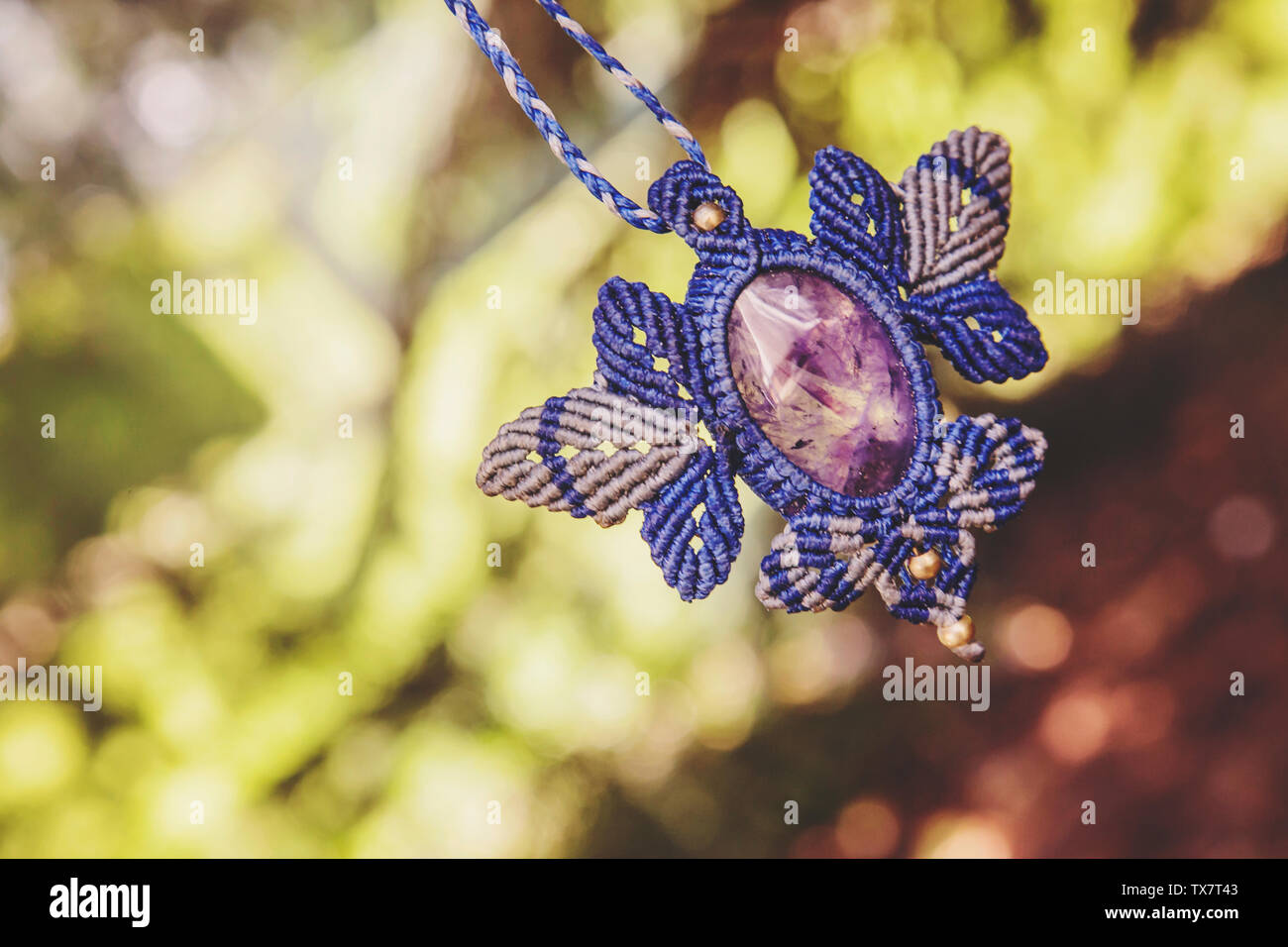 Macrame necklace with amethyst stone on natural background Stock Photo