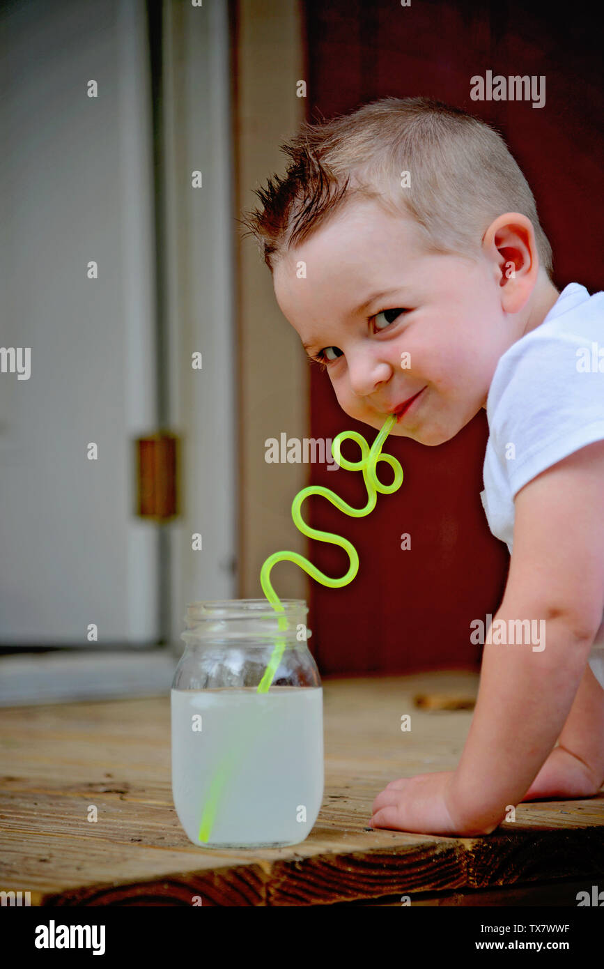 young boy drinking from a silly straw Stock Photo
