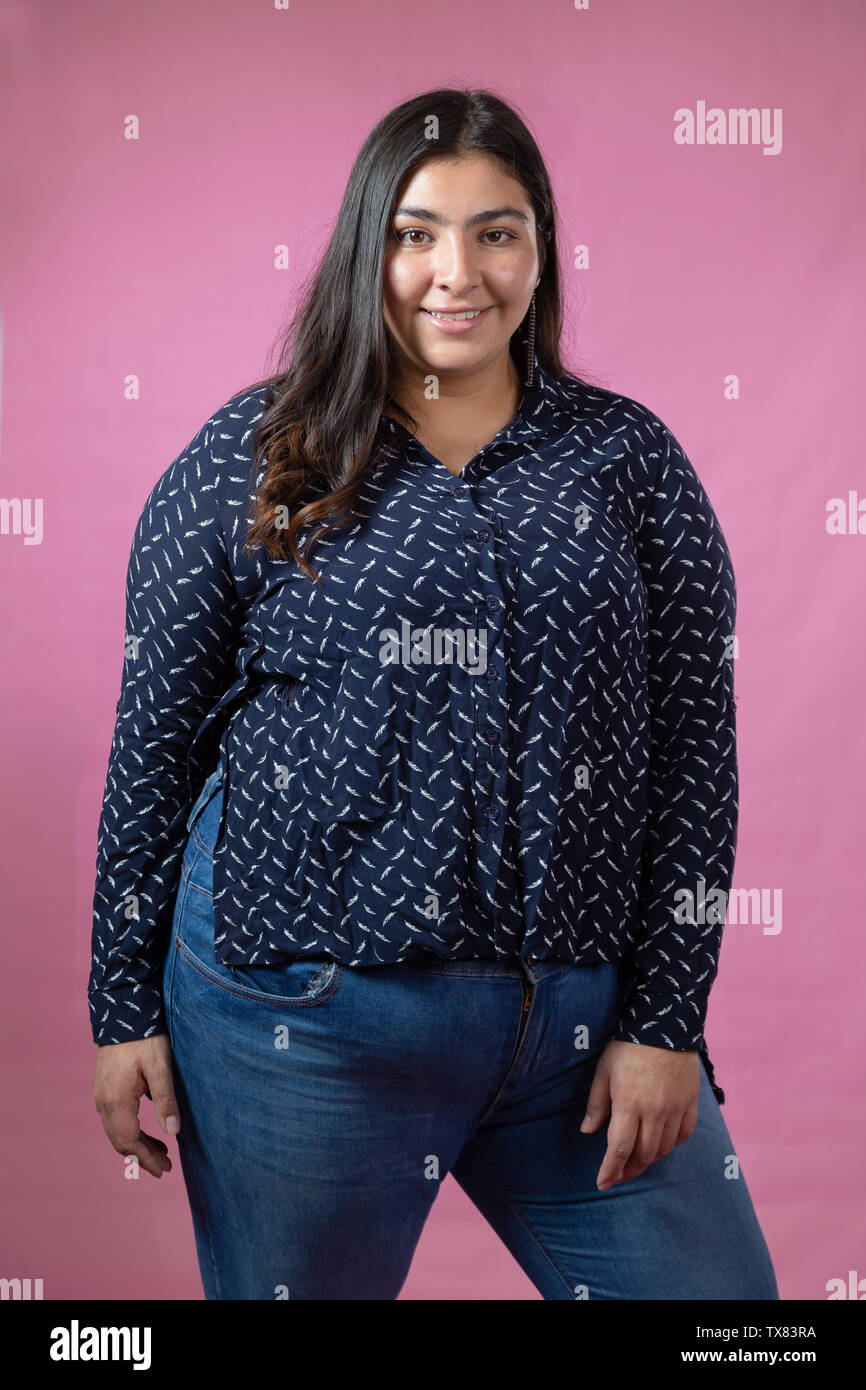 chubby-woman-standing-in-studio-with-pink-background-stock-photo-alamy
