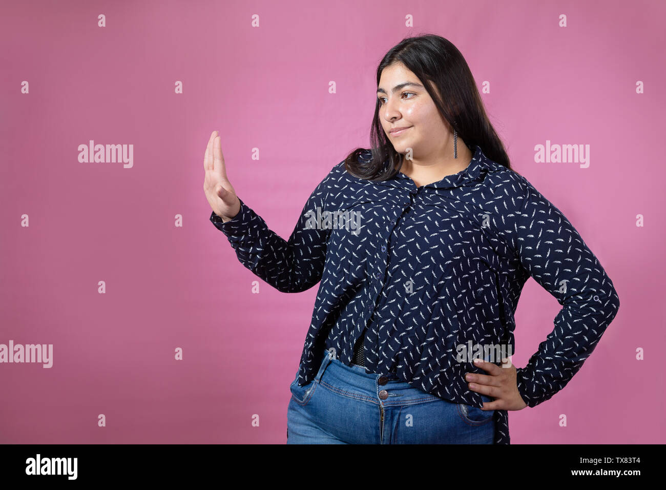 Beautiful chubby woman dancing and singing with pink background Stock