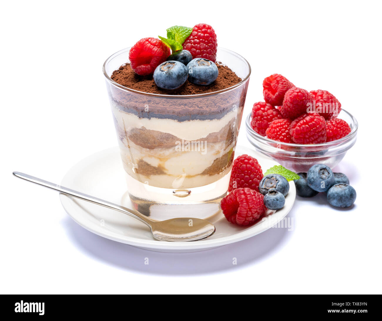 Classic tiramisu dessert with blueberries and raspberries in a glass ...