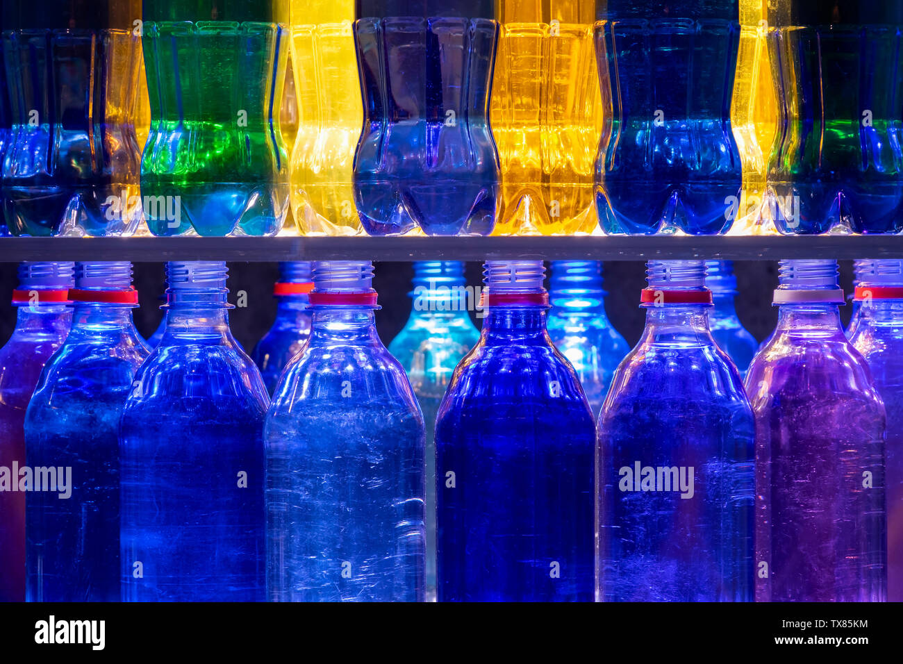 Colourful Plastic Bottles stacked on shelves Stock Photo