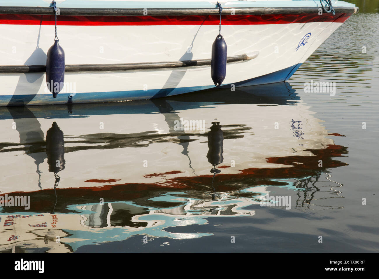 reflection on ripples on water of motor cruiser, boat, holiday boat, the Norfolk Broads, UK, mirror image. Stock Photo