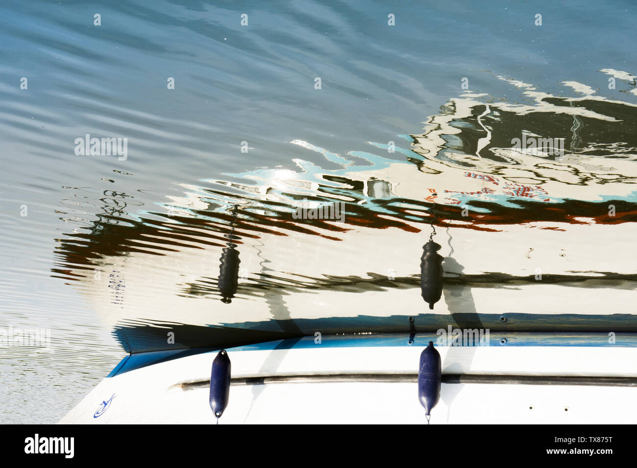 reflection on ripples on water of motor cruiser, boat, holiday boat, the Norfolk Broads, UK, mirror image. Stock Photo