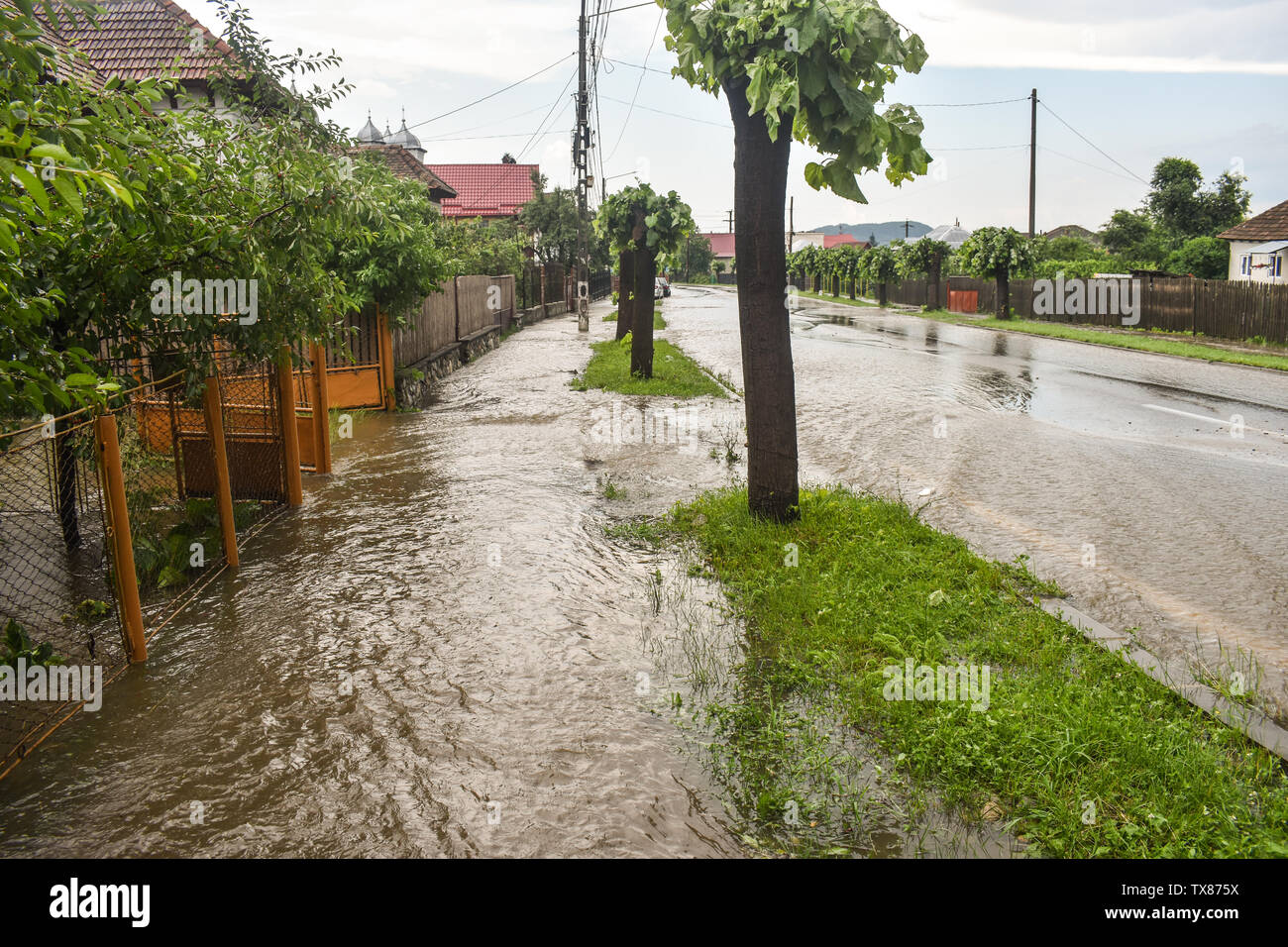 Flooded city street after thunderstorm. The road and the sidewalk are ...