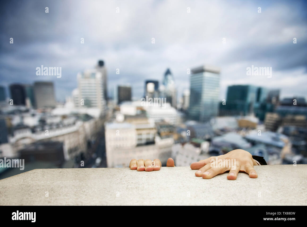 Man clambering onto the roof of a building Stock Photo