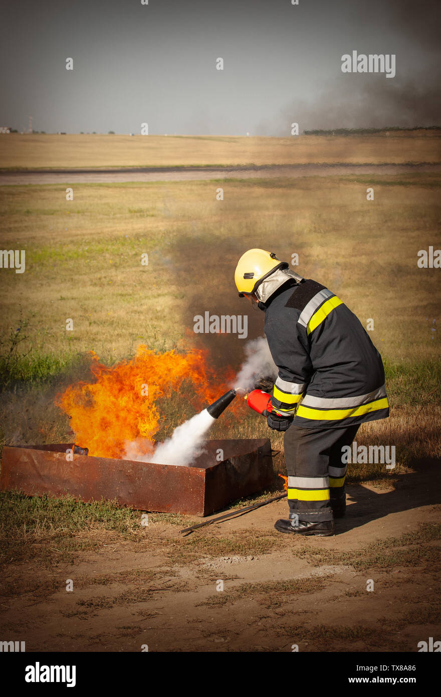 Instructor showing how to use a fire extinguisher on a training fire Stock Photo