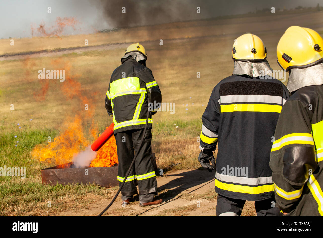 Instructor showing how to use a fire extinguisher on a training fire Stock Photo