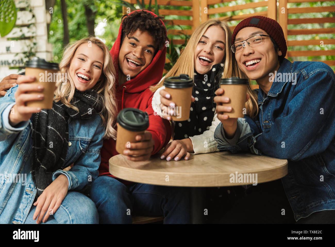 Happy multhietnic friends students hanging out together outdoors