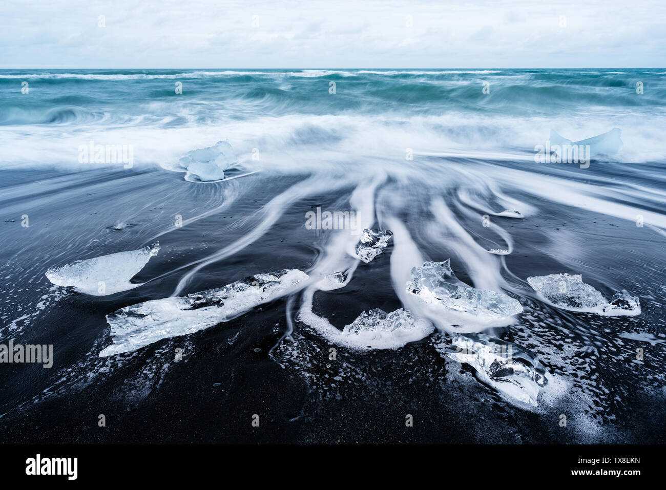 Icy beach in Iceland, Europe. Iceberg on the black volcanic sand on the Atlantic Ocean. Tourist attraction. Amazing landscape, cloudy day Stock Photo