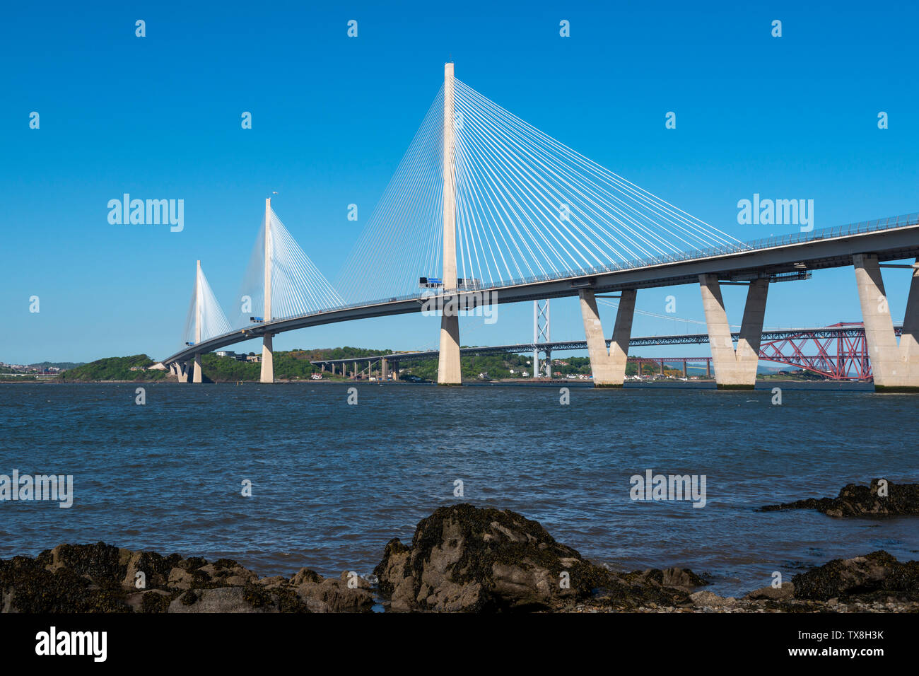 New Queensferry Crossing road bridge, with Forth Road Bridge and Forth Railway Bridge in background, viewed from South Queensferry, Scotland, UK Stock Photo