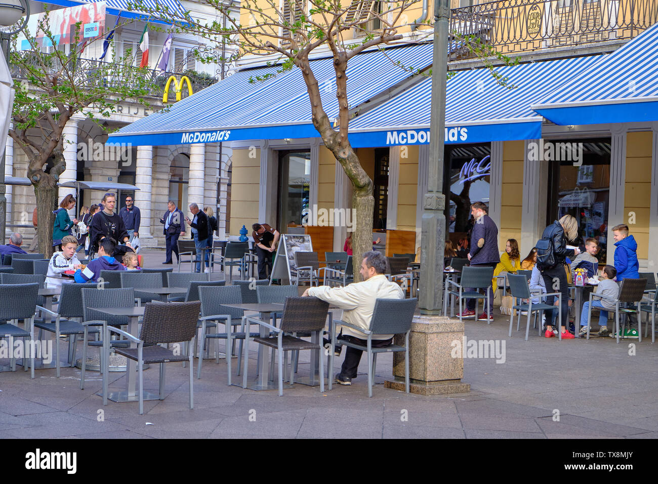 April 18, 2019 : People sitting and enjoying meals purchased at McDonald's restaurant in the city centre square Stock Photo