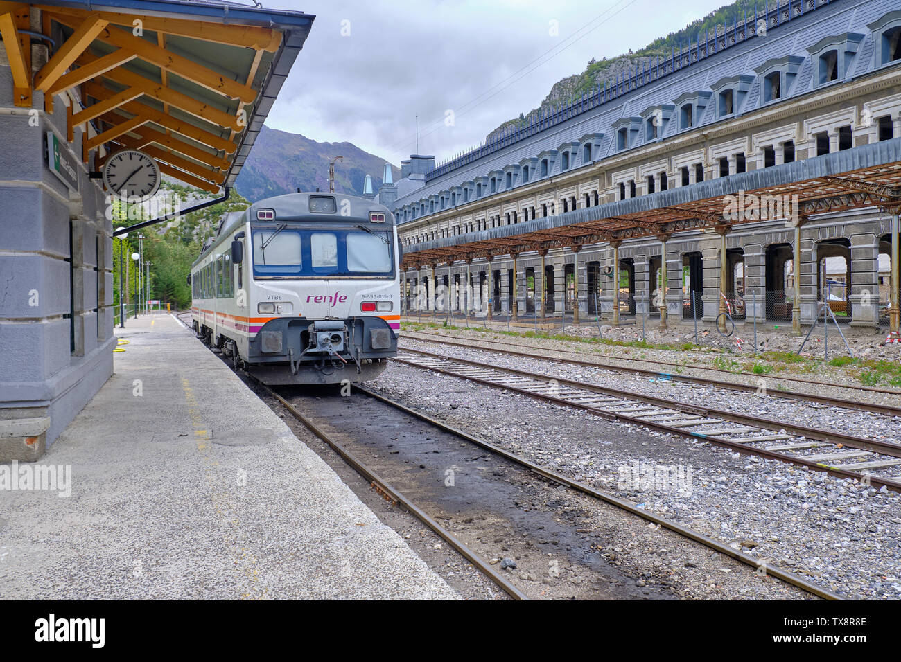 One car train waiting in station on small platform next to the former abandonned one from the town's glory days. Canfranc Estacion, Spain, May 28, 201 Stock Photo
