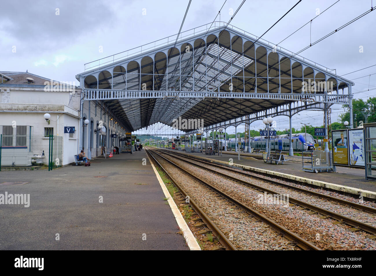 The old style Pau Station.  Metal frame covering the Platforms and tracks and electrical wires above. Pau, France, June 8, 2019 Stock Photo