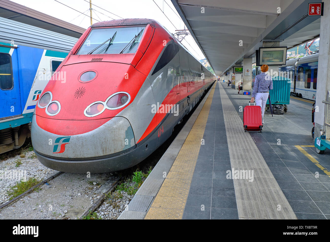 Italian IC train waiting in Station before departing for Venice, with one passenger on platform