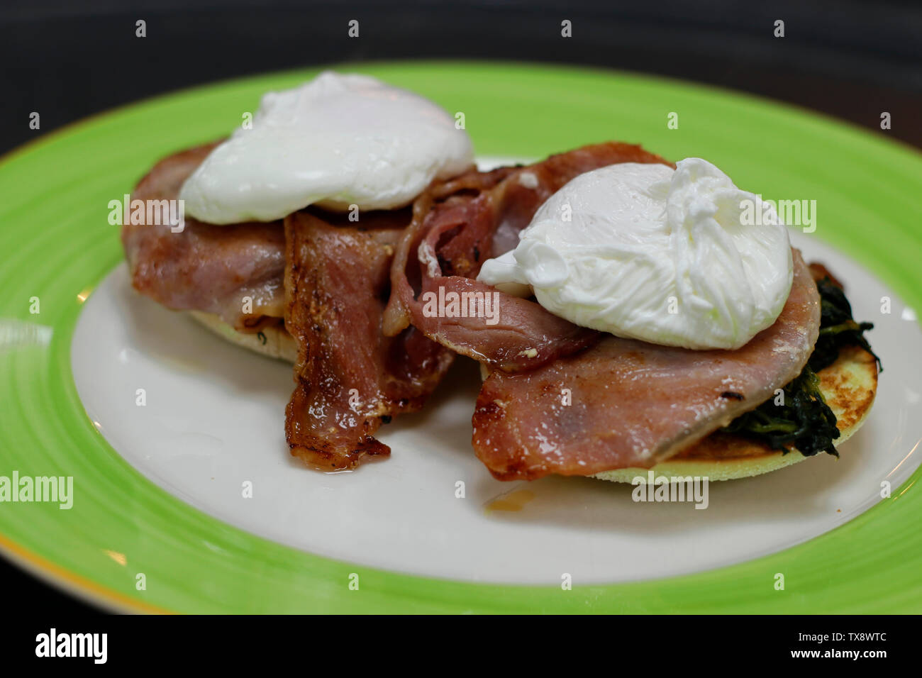 egg Benedict with poach egg, bacon and spinach Stock Photo