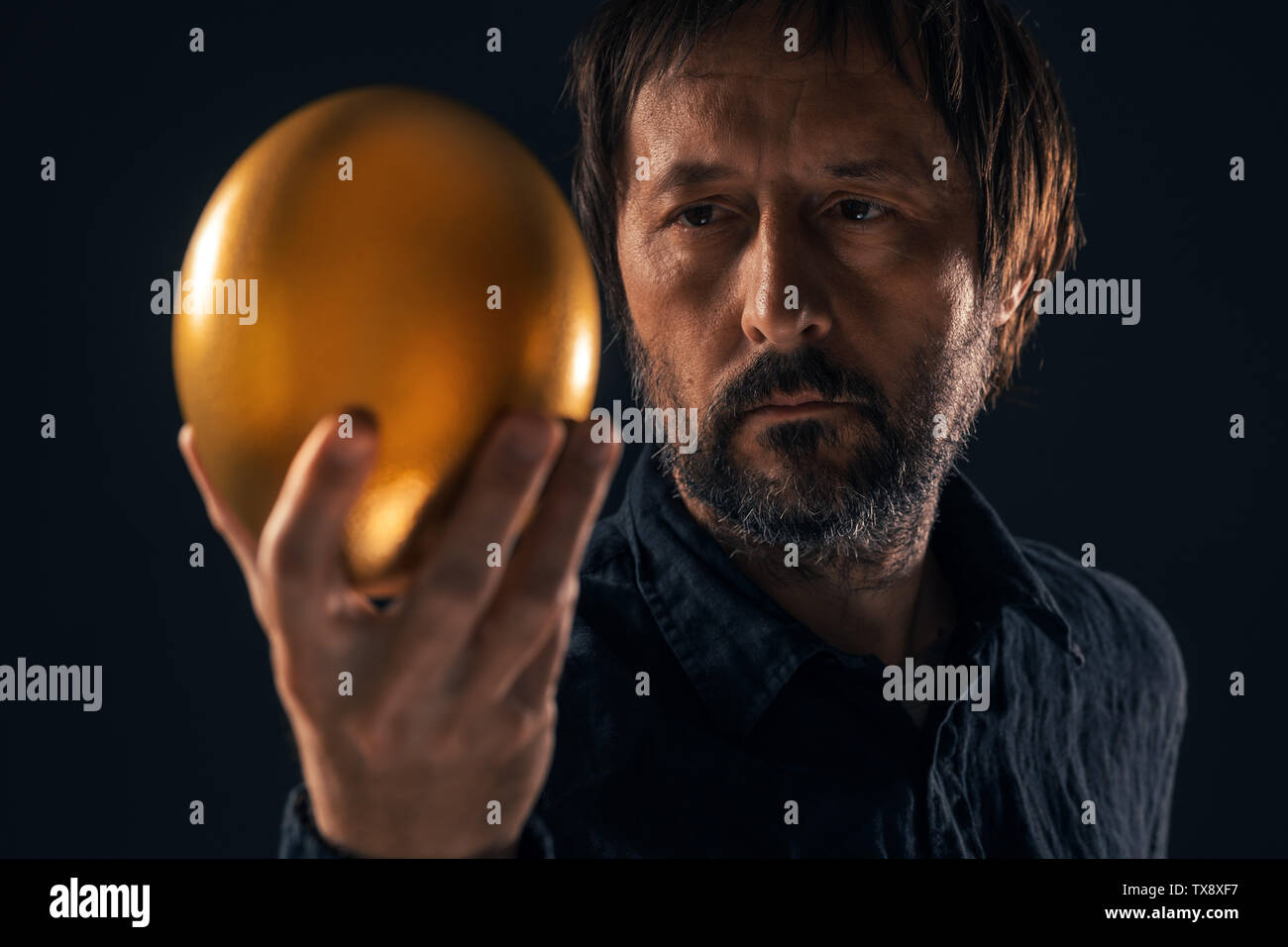 Man and golden egg. Valuable business resources and investment opportunity concept. Stock Photo