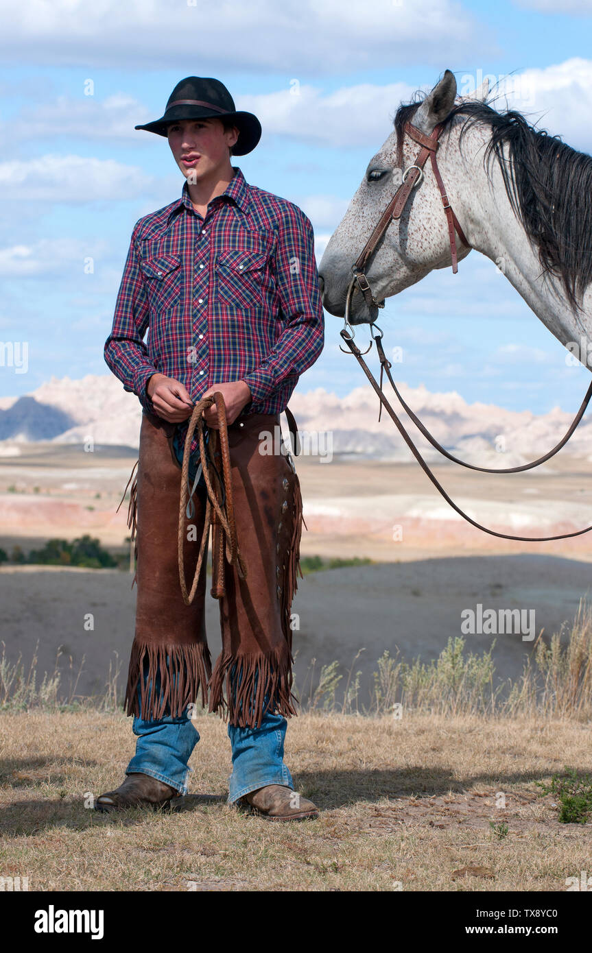 Young cowboy with chaps and whip with his Appaloosa horse, South Dakota, USA Stock Photo