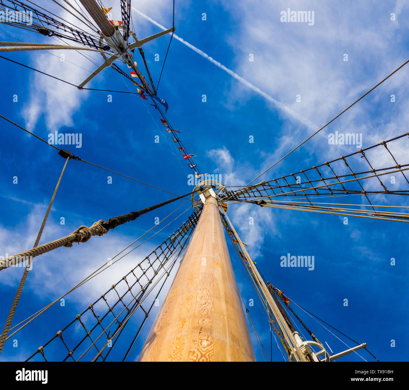 Masts and rigging of a sailing ship against the blue sky background ...