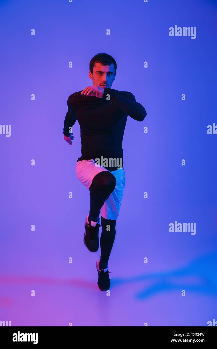 Running Portrait Full length portrait of a fit sportsman running isolated over violet ...