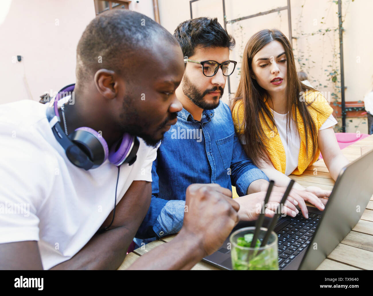 Three multicultural smart students studying at the open air Stock Photo