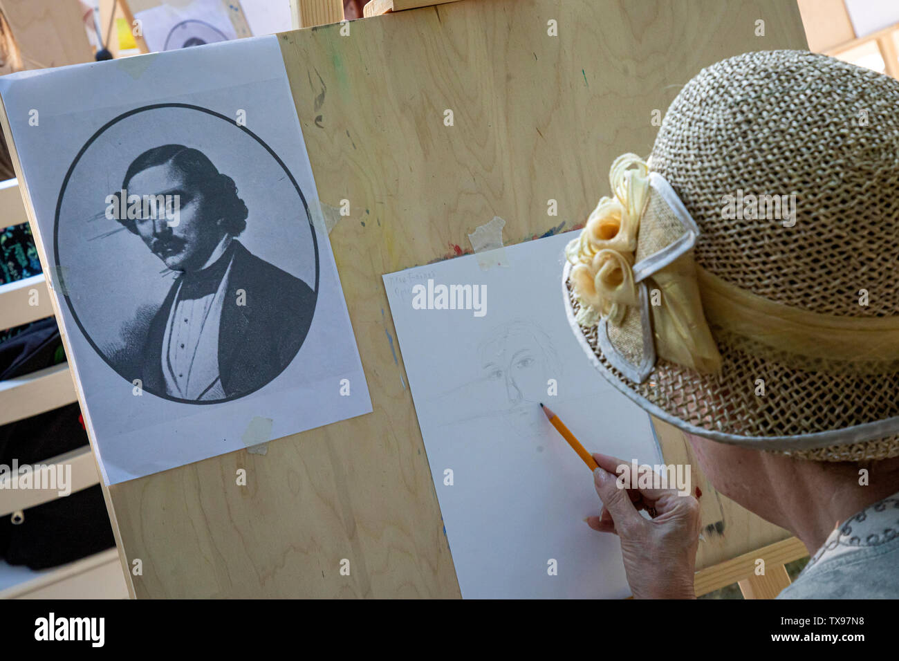 A woman draws a portrait of the famous French circus artist Jean-Baptiste Auriol in the center of Moscow during festival 'Moscow - Paris', Russia Stock Photo