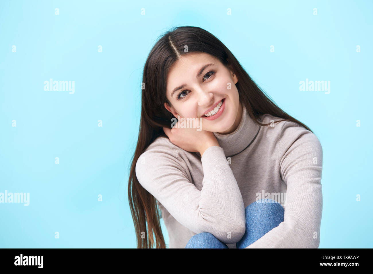 studio portrait of a beautful caucasian woman, sitting on floor ...