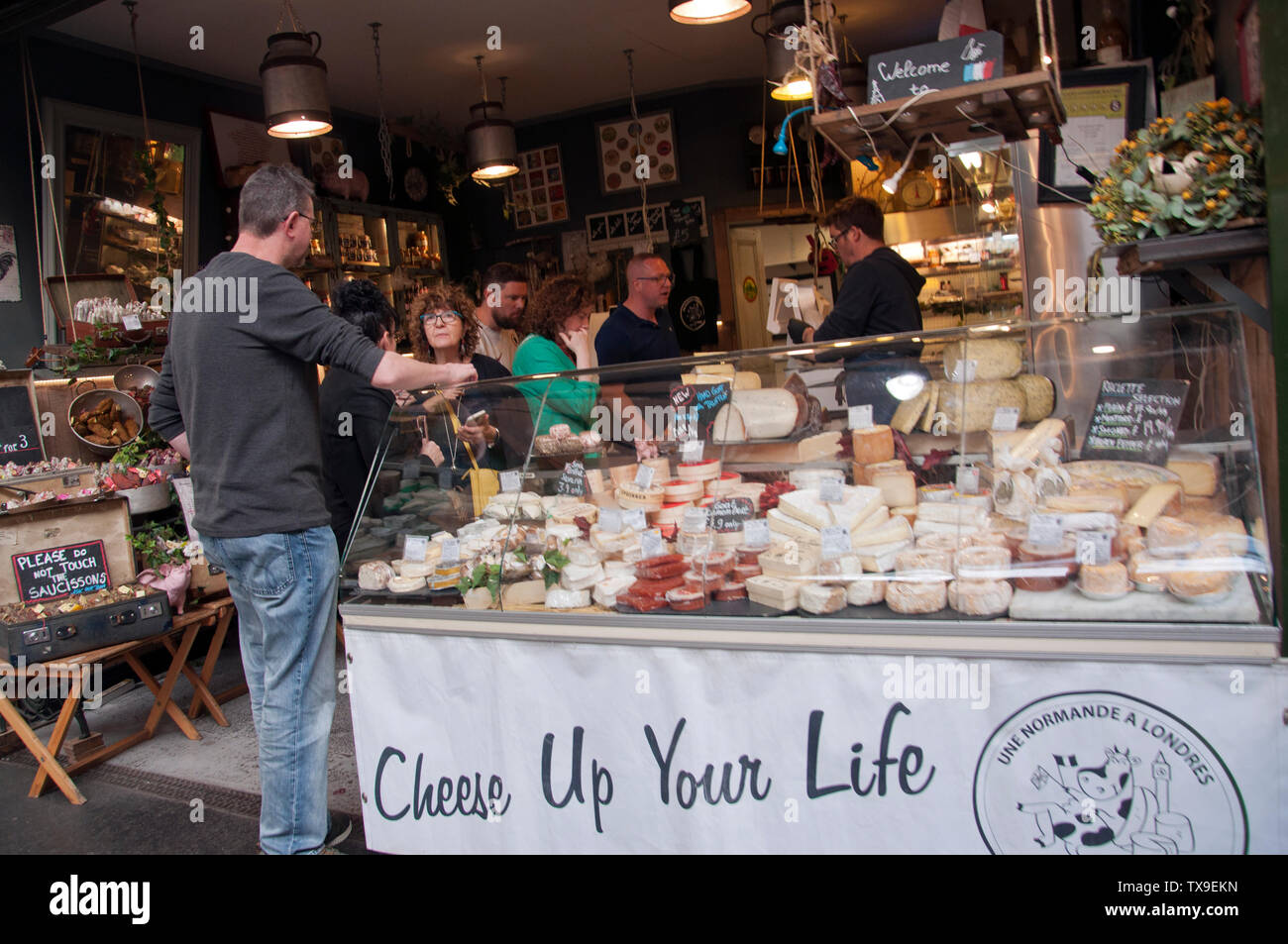 Shoppers at a Cheese Market stall in Borough Market, London, England