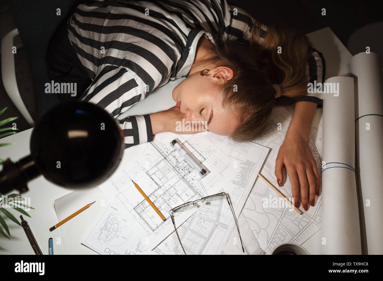 Close up of a business woman architect sleeping on her desk at the ...