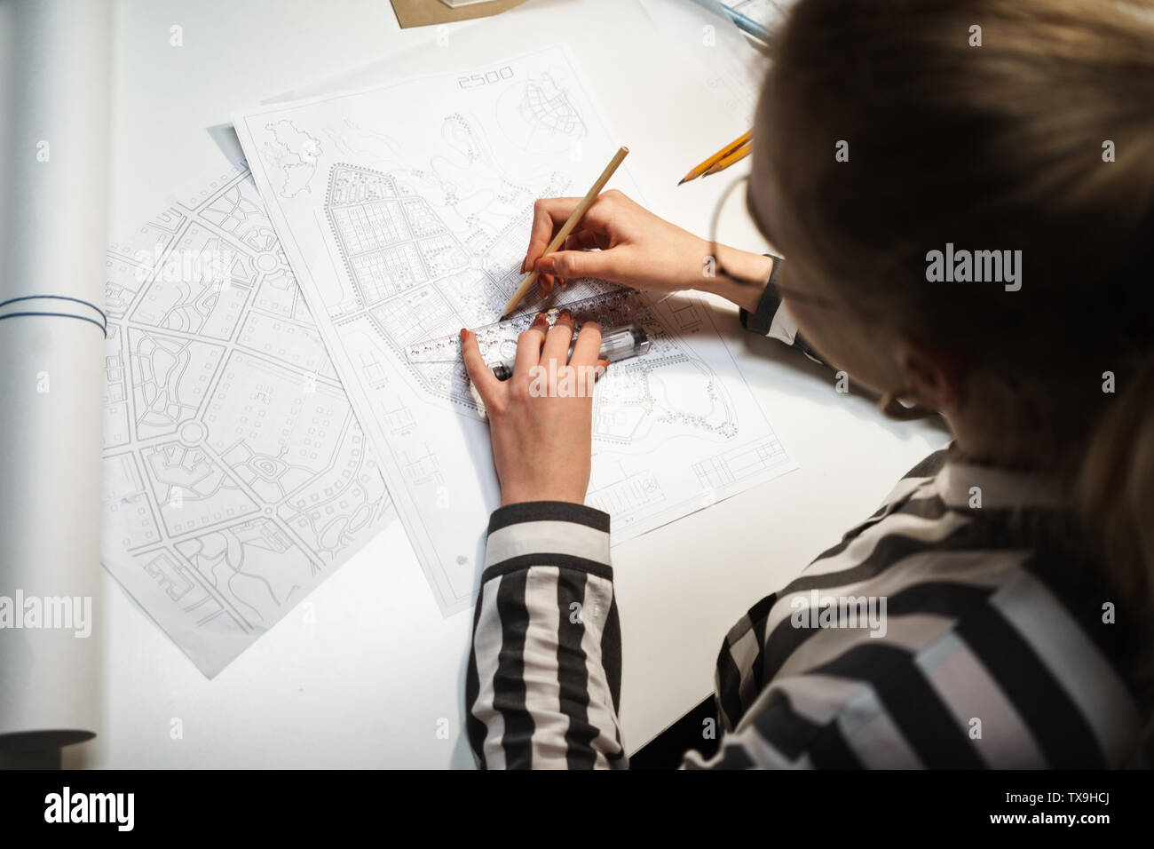 Top view of a young woman architect working over a new project at her workplace Stock Photo