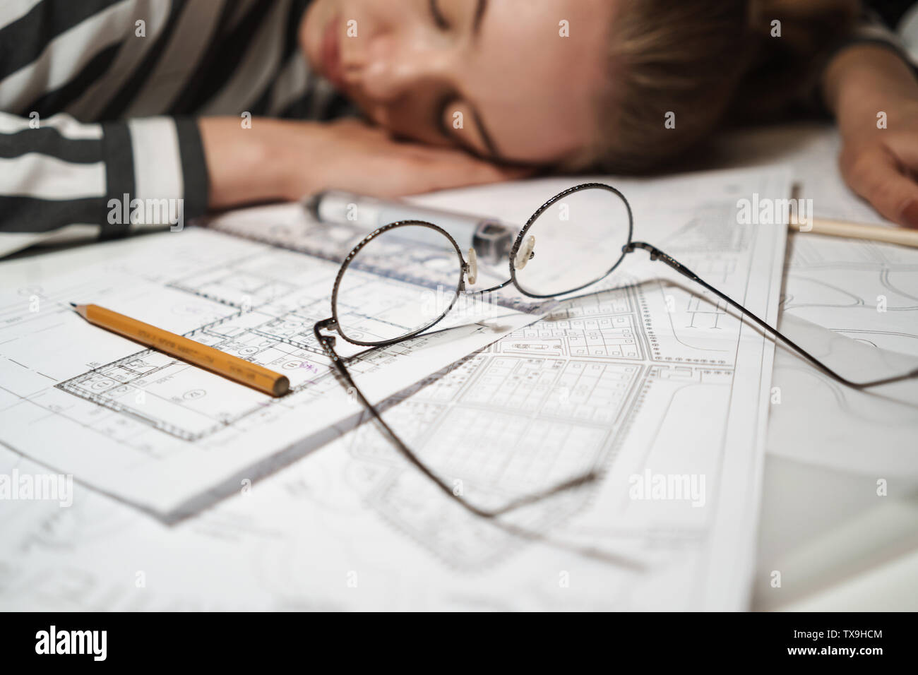 Close up of a business woman architect sleeping on her desk at the ...