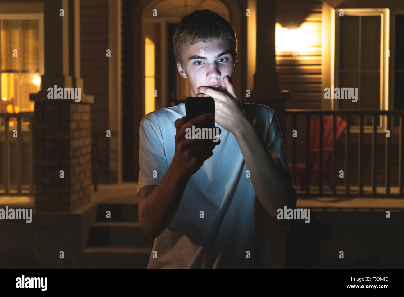 Teenager looking at something shocking on his mobile phone. He is