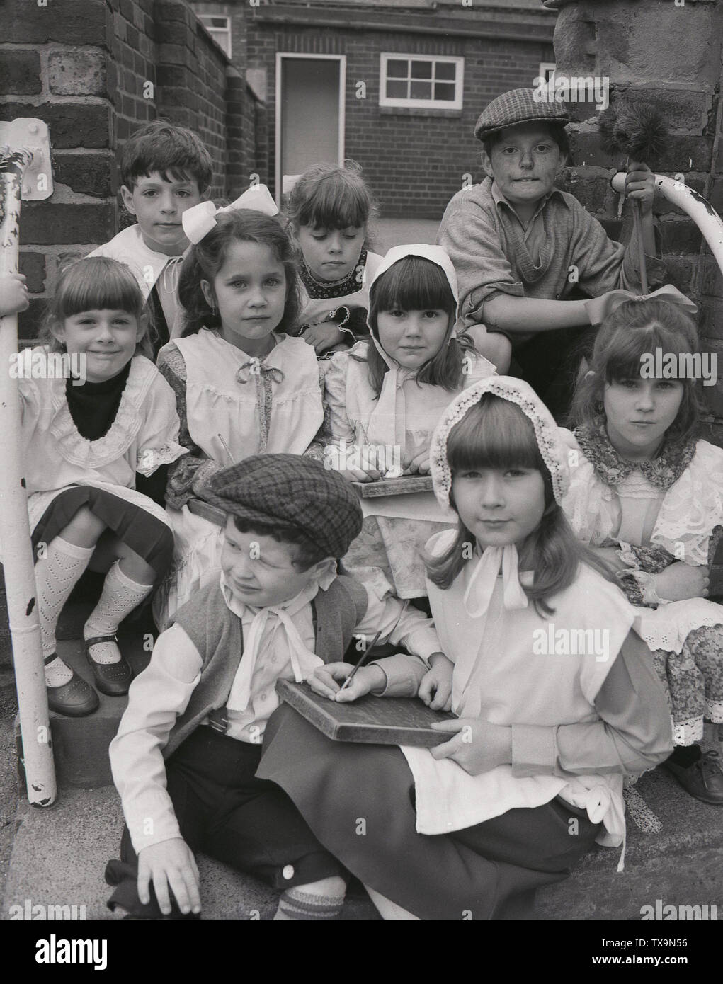 1980s, group of young school children dressed up in the clothes of those who went to a village primary school from yesteryear, 100 years ago, Yorkshire, England, UK. Stock Photo