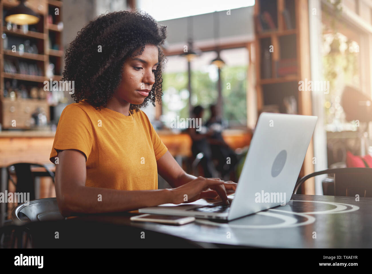 An african woman using laptop at coffee shop Stock Photo