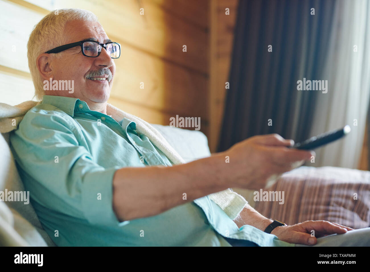 Cheerful senior grey-haired man in eyeglasses and shirt Stock Photo