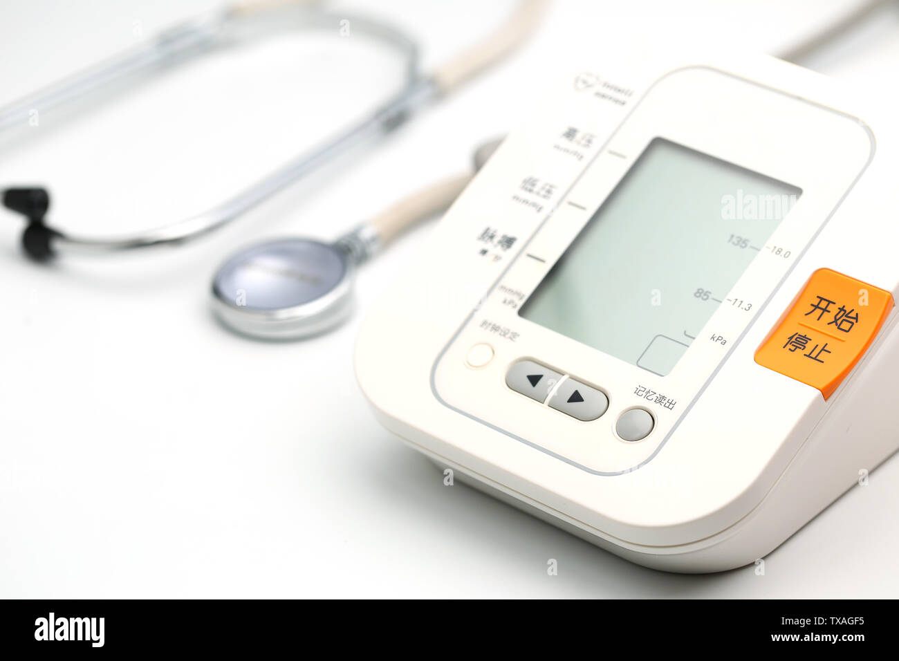 Electronic sphygmomanometer and stethoscope are placed on white