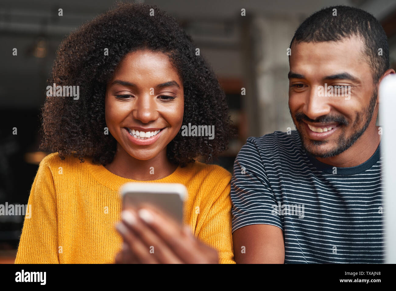Smiling african couple looking at cellphone Stock Photo