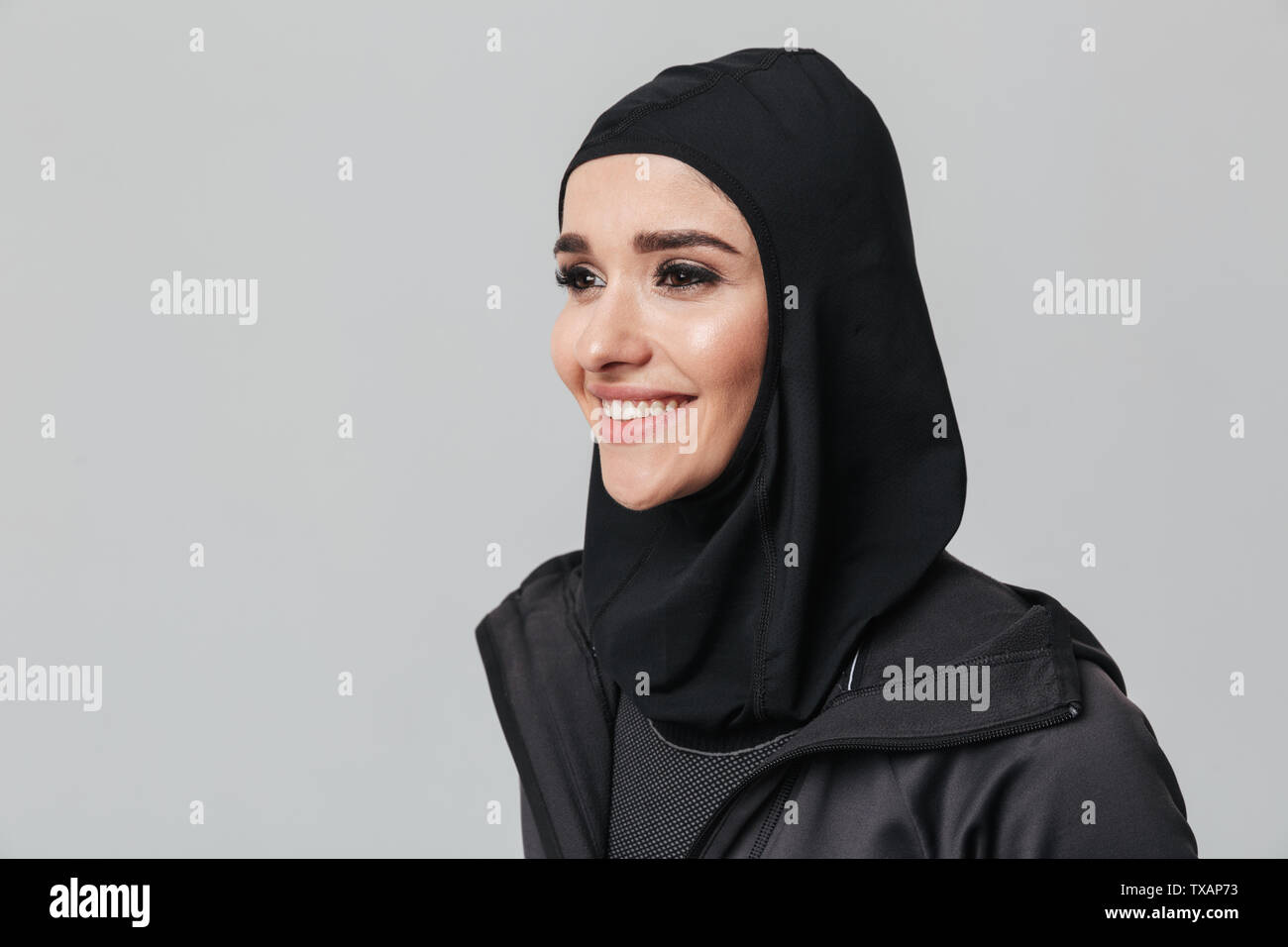 Attractive young muslim woman wearing sport hijab isolated over white ...