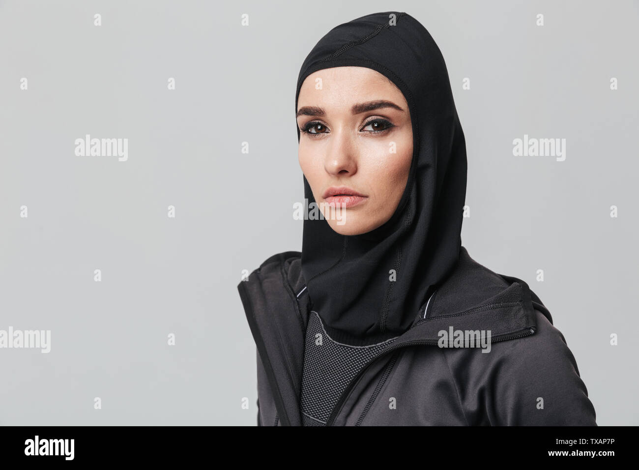 Attractive young muslim woman wearing sport hijab isolated over white ...