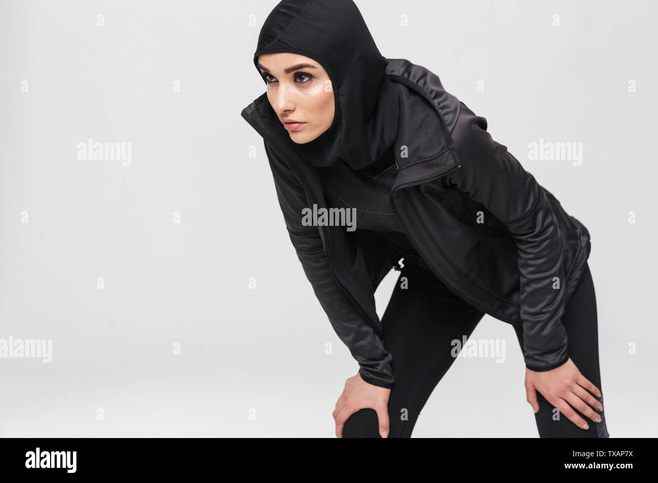 Attractive young muslim woman wearing sport hijab isolated over white ...