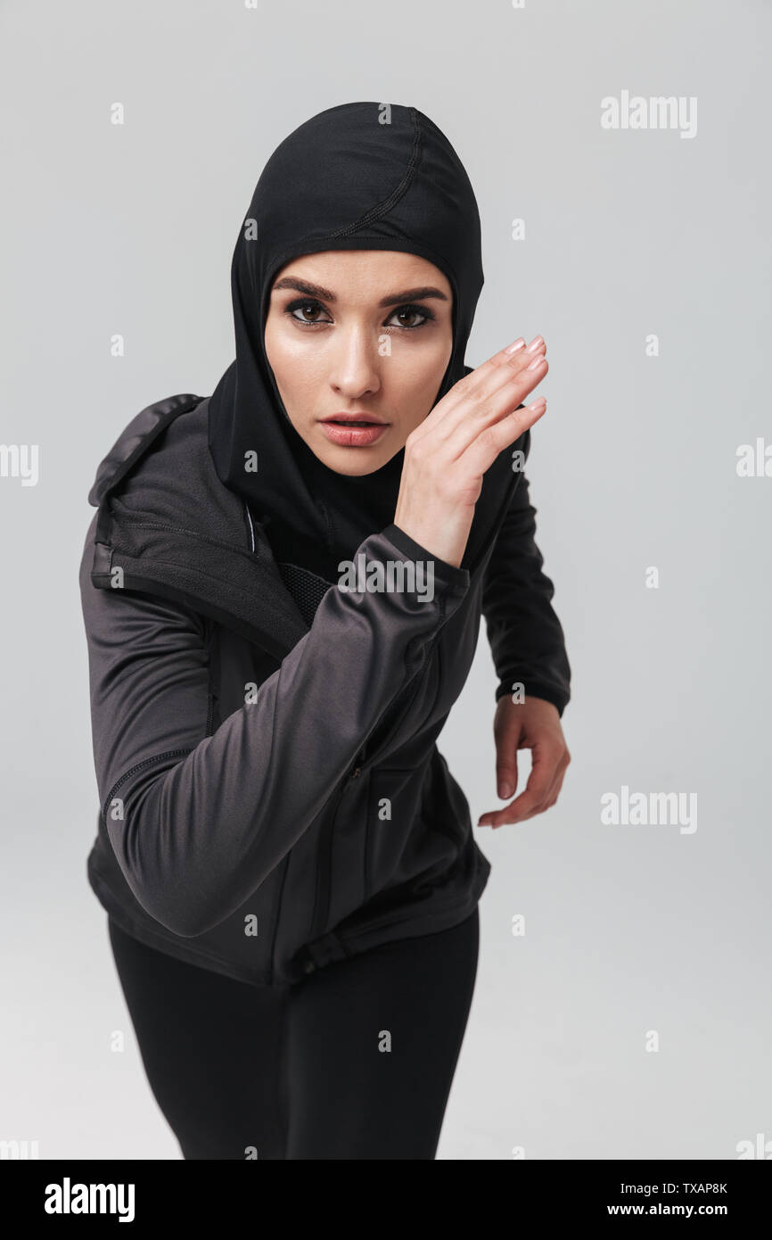 Attractive confident young muslim woman wearing sport hijab running ...