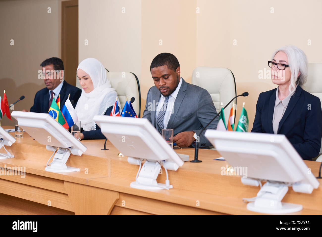 Row of contemporary young and mature intercultural politicians Stock Photo
