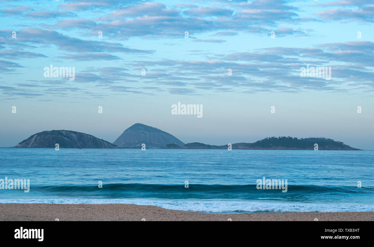 Dramatic landscape of Ipanema beach, looking to the sea, early morning, blue tonalities of water and sky with nobody. Rio de Janeiro, Brazil. Stock Photo