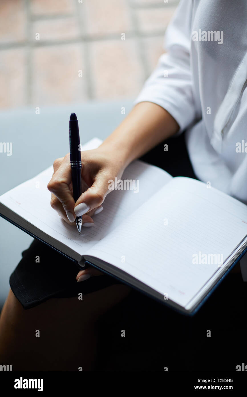 Closeup of unrecognizable businesswoman writing on blank paper in planner, copy space Stock Photo