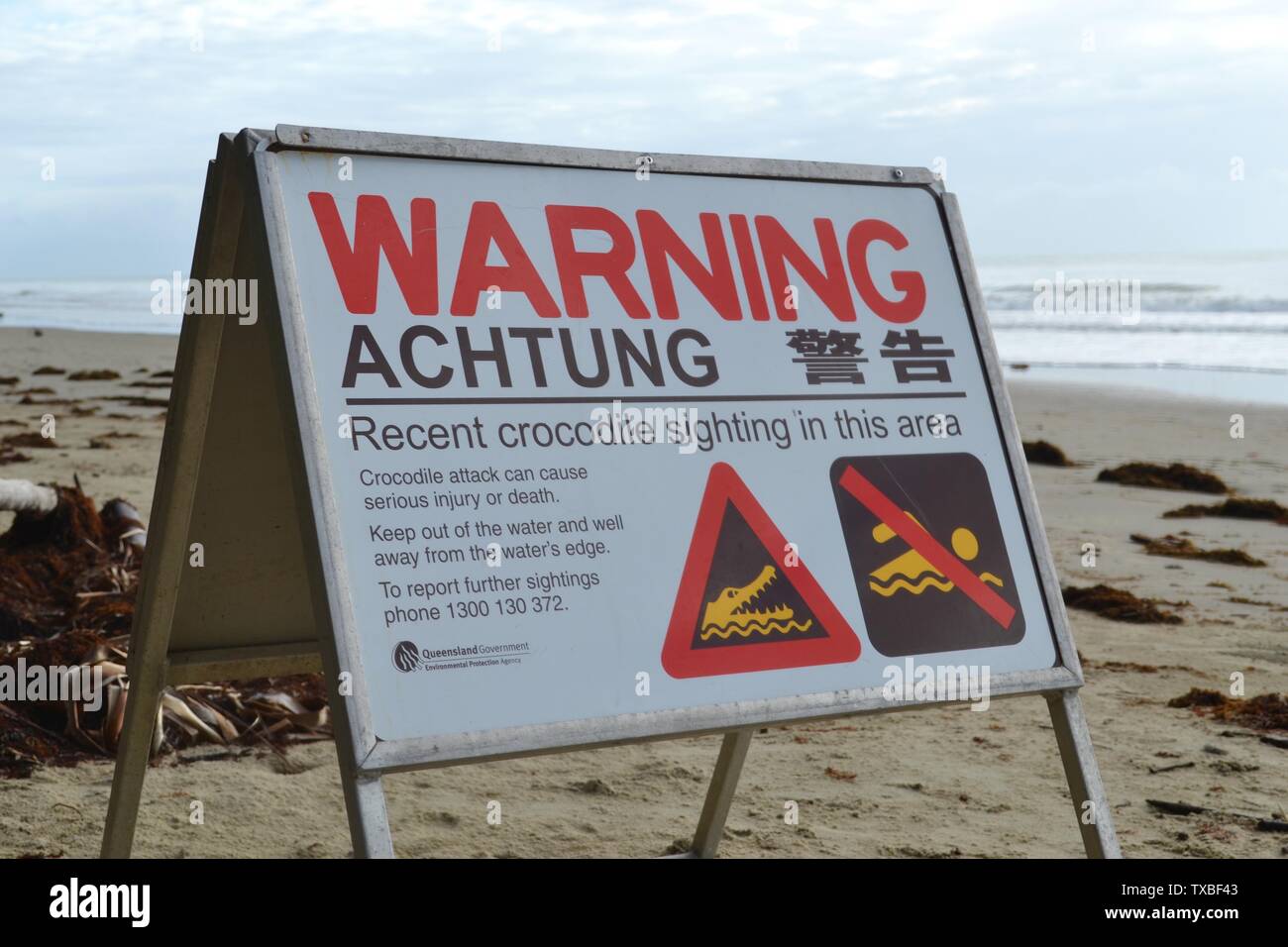 No Swimming warning sign for crocodiles on the beach in Port Douglas in Far North Queensland Stock Photo