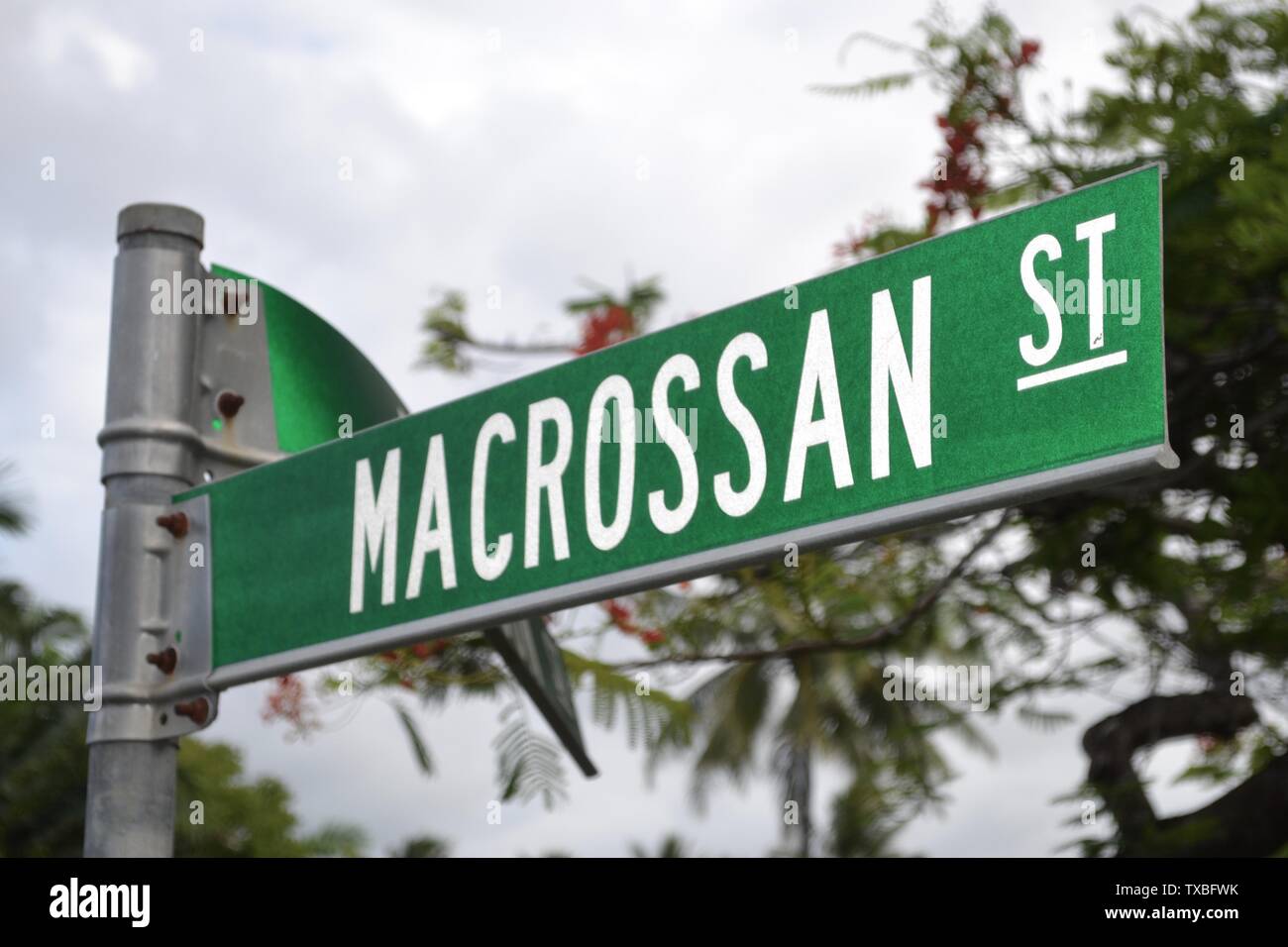 Street name sign for the upmarket shopping strip Macrossan Street in Port Douglas Australia Stock Photo
