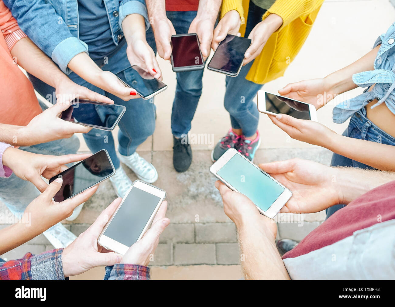 Group of friends using their smart mobile phones - Millennial young people addicted to new technology trends Stock Photo