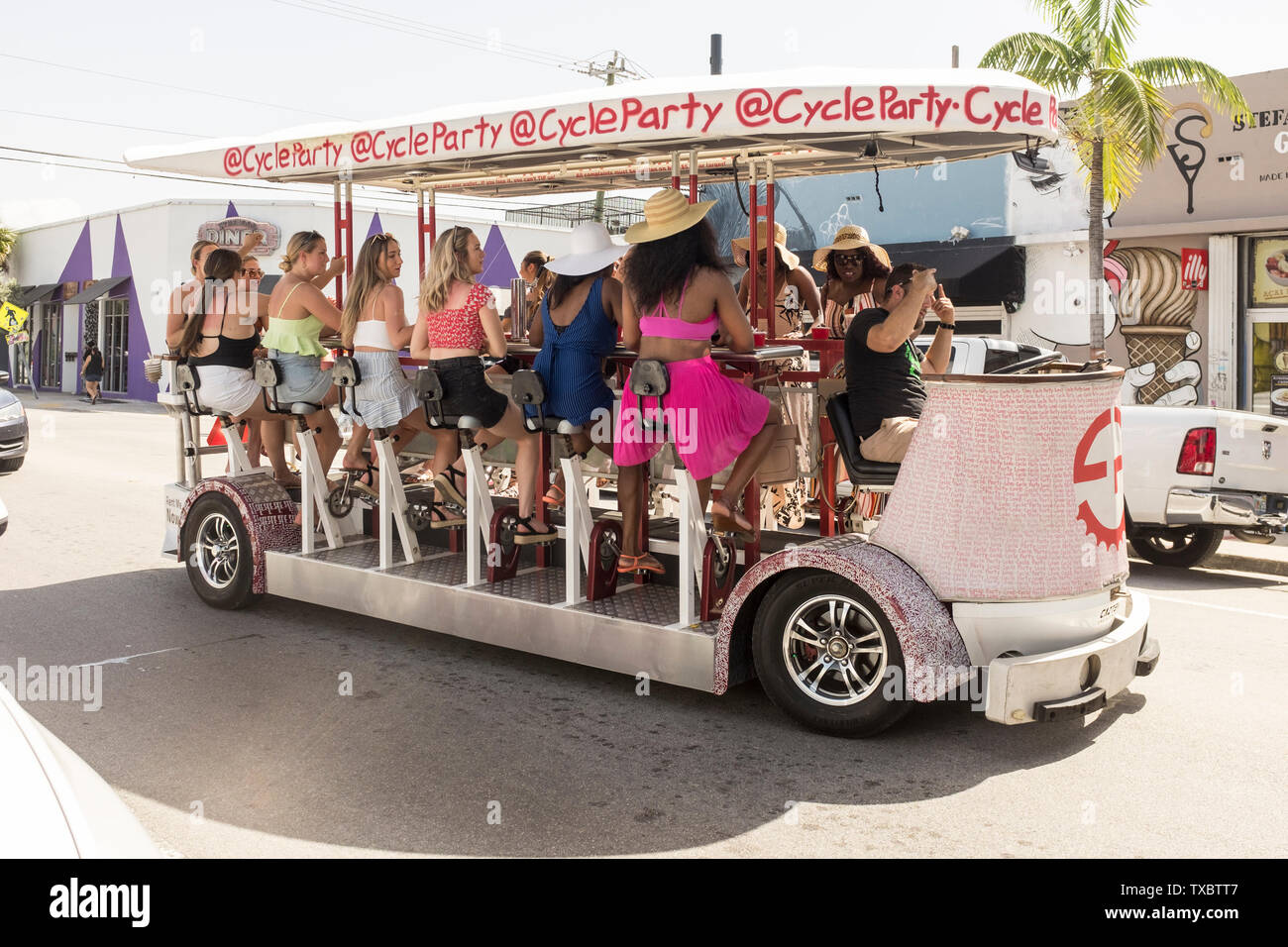 A group of young women on a party bike in the daytime in Wynwood, Miami, Florida Stock Photo