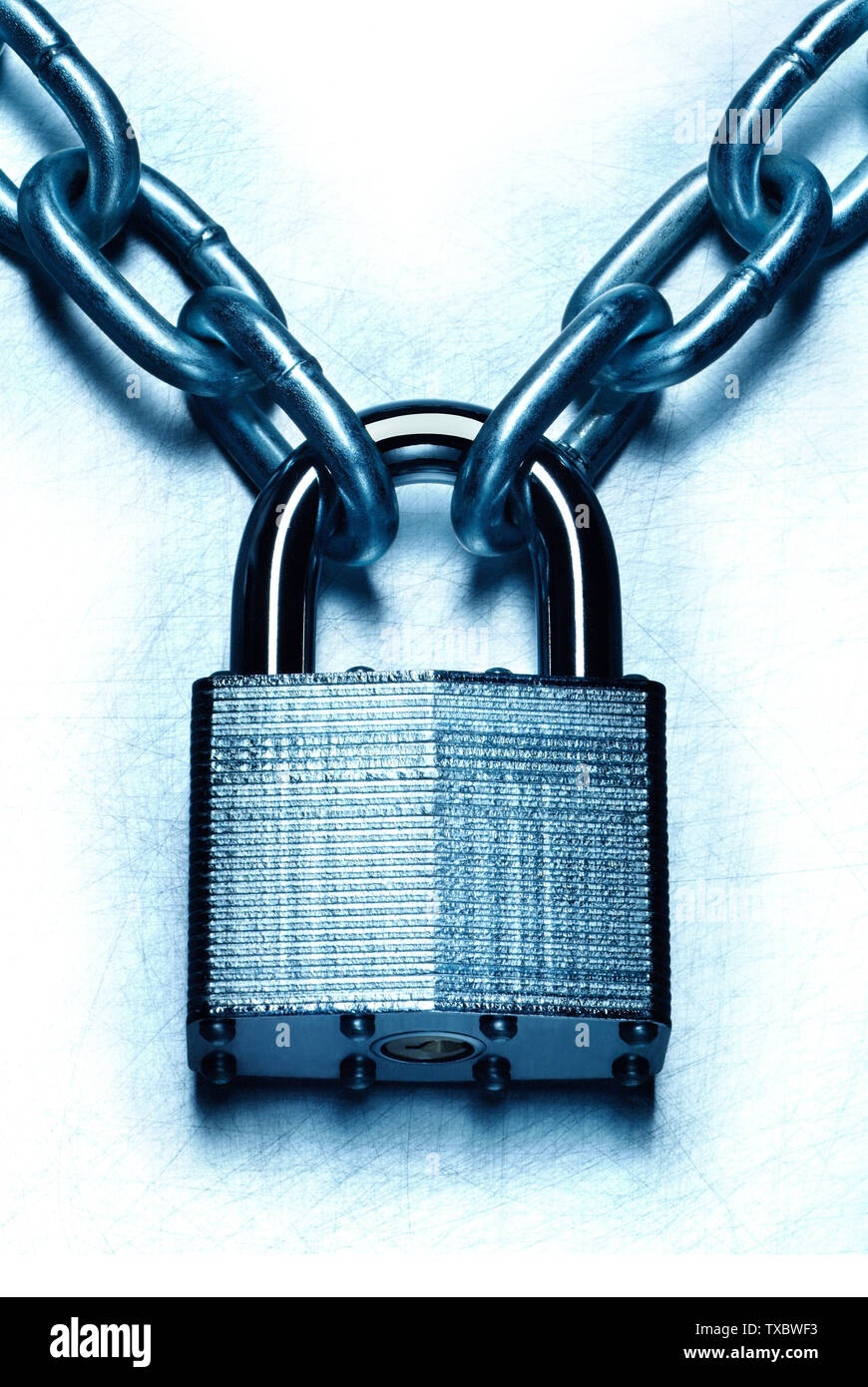 Impenetrable security concept. Closeup image of chain and locked padlock  on blue steel white background Stock Photo